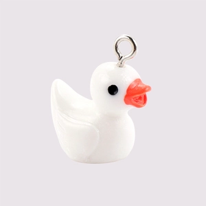 Close-up of a cute white resin duck charm with a metal ring for DIY jewelry making