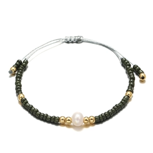 Detail of beaded bracelet featuring a white freshwater pearl and adjustable cord