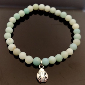 Pulsera elástica de cuentas de amazonita natural con un dije de mariquita en plata