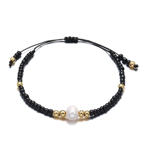 Ethnic handmade black seed bead bracelet with golden accents and a freshwater pearl