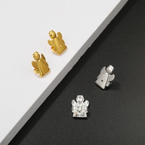 Macro detail of Magic Bax earring lifters in polished gold and silver angel wing design