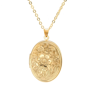 Vintage gold oval locket necklace with floral engraving on a classic cable chain