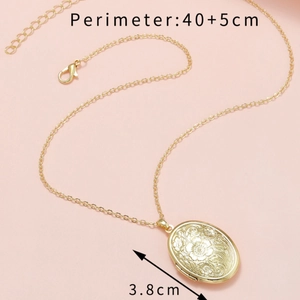 Gold oval locket necklace with engraved floral pattern on adjustable lobster clasp chain