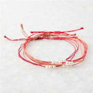 Lot de trois bracelets en perles naturelles tressées avec cordons rouges réglables