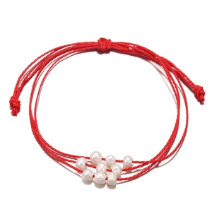 Vue détaillée d'un bracelet en corde rouge tressée avec des perles d'eau douce