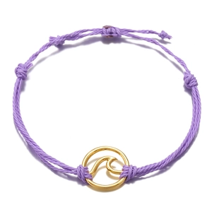 Close-up of handmade purple woven rope bracelet with a gold wave charm and adjustable knot