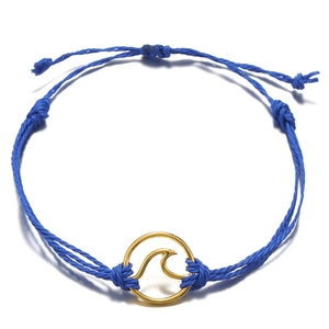 Handmade bohemian beach wave bracelet featuring blue wax cord and gold wave charm