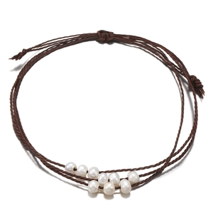 Détail du bracelet en cordon ciré marron tressé à la main avec perles naturelles