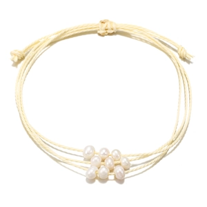 Détail d'un bracelet en coton tressé multi-rangs avec neuf perles d'eau douce naturelles