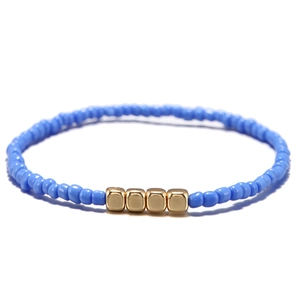Dettaglio del bracciale bohémien con perline azzurre e distanziatori quadrati dorati