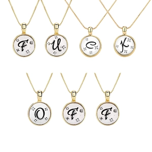 Macro detail of gold-plated necklaces with alphabet pendants and sparkling cubic zirconia