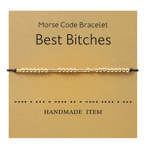 Detail of Morse Code gold beads on black rope bracelet with Best Bitches gift card