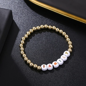Golden bead bracelet with colorful FAMILY letter cubes on a black textured background