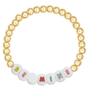 Close-up of golden beads and white letter beads spelling BE MINE on a stylish bracelet