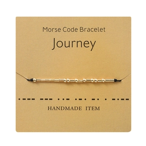 Detail of Morse code bracelet with gold beads on display card for unique handmade gift