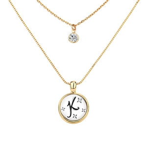 Detail shot of a double-layered gold necklace with letter K pendant and zircon stones