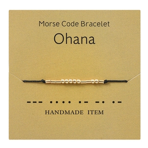 Golden Morse code bracelet on Ohana card with handmade woven rope and beads