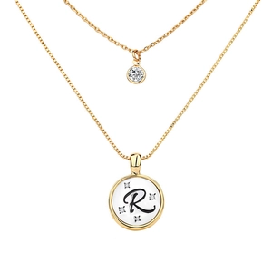 Close-up of double-layer gold necklace featuring a zircon pendant and letter R disc