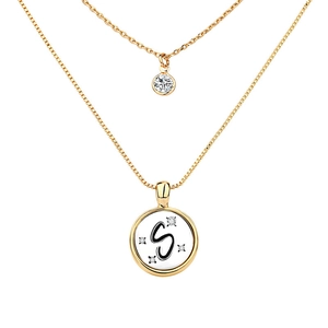 Detail of layered gold initial S necklace with sparkling cubic zirconia accents