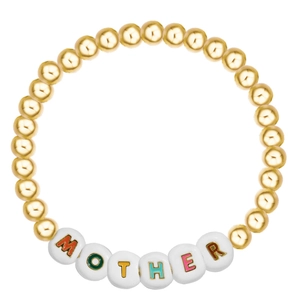 Detailed macro view of golden beads and white acrylic cubes spelling MOTHER on a bracelet