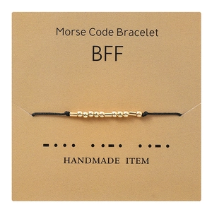 Detail of Morse code bracelet with gold beads on a BFF display card for friends