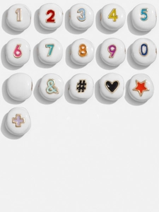 Macro shot of white ceramic beads with colorful gold-rimmed numbers and symbols for DIY jewelry