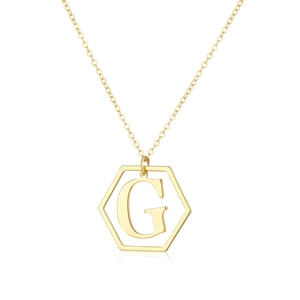 Macro detail of golden hexagonal pendant with letter G and classic link chain