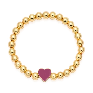Dettaglio del bracciale con perline dorate e ciondolo a cuore in smalto prugna