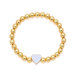 Dettaglio di un bracciale a sfere dorate con ciondolo a cuore lilla e bordo in oro