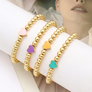 Dettaglio del set di 4 braccialetti di perline dorate con ciondoli a cuore smaltati