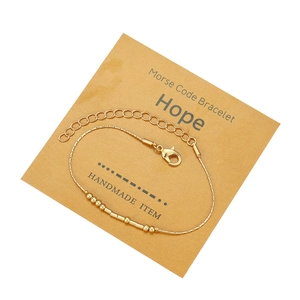 Dettaglio del bracciale a codice Morse dorato con carta Hope e chiusura regolabile