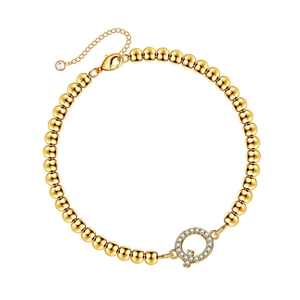 Detailed macro view of gold beaded bracelet featuring a sparkling crystal pave letter Q charm