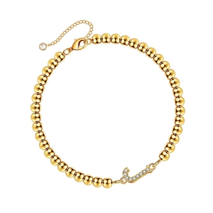 Golden beaded bracelet with a sparkling crystal-encrusted letter J pendant and lobster clasp