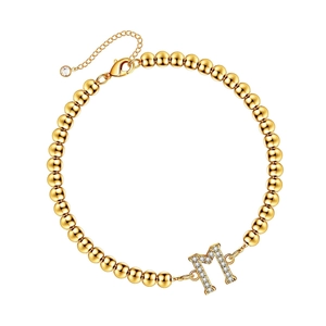Gold beaded bracelet with sparkling rhinestone encrusted letter M charm and lobster clasp