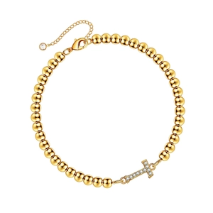 Gold beaded bracelet featuring a horizontal cross charm paved with clear cubic zirconia