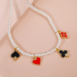 Elegante collar de perlas con colgantes de cartas de póker sobre fondo rosa suave