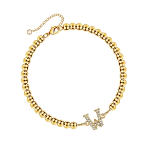 Minimalist golden beaded bracelet with crystal-studded letter W charm and lobster clasp