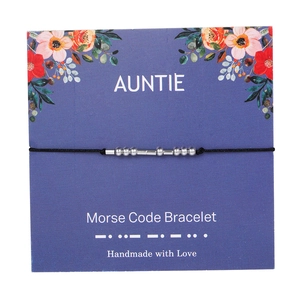 Detail of handmade Morse code auntie bracelet with silver beads on a floral card