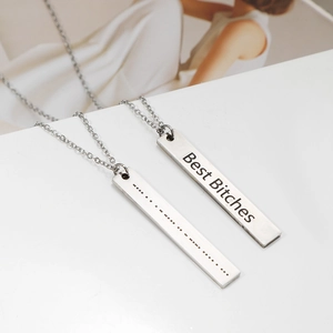 Close-up of Morse code pendant and Best Bitches engraved bar necklace set in silver