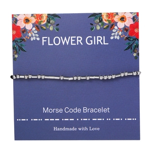 Detailed view of Morse code bracelet with silver beads on floral display card