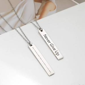 Detail of Morse code bar necklace with Never Give Up engraving in stainless steel