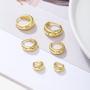 Three pairs of polished gold-plated hoop earrings in different sizes on a white background