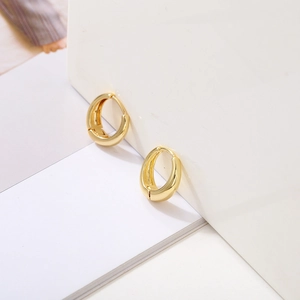 Detail view of high-polished gold-plated thick hoop earrings with invisible hinge closure