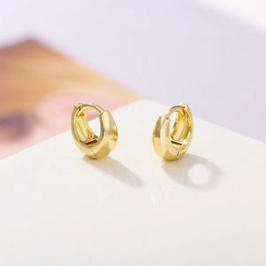 Detail view of high-polished gold-plated circular huggie hoop earrings on display