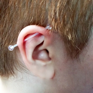 Piercing industriel en acrylique transparent sur l'oreille avec billes rondes claires