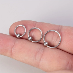 Three-piece silver stainless steel captive bead ring set in varied sizes on a finger