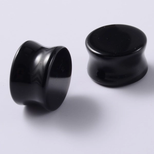 Close-up of polished black onyx double flared ear plugs with a mirror finish surface
