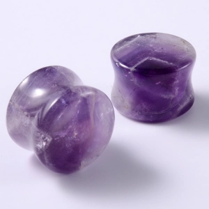 Macro detail of double flared natural amethyst ear plugs with unique purple stone textures