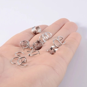 Λεπτομερής κοντινή λήψη σετ ασημένιων ear cuffs στην παλάμη για σύγκριση μεγέθους