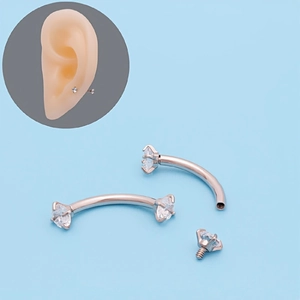 Rose gold curved barbell eyebrow ring with 4-prong zircons and silicone ear model view
